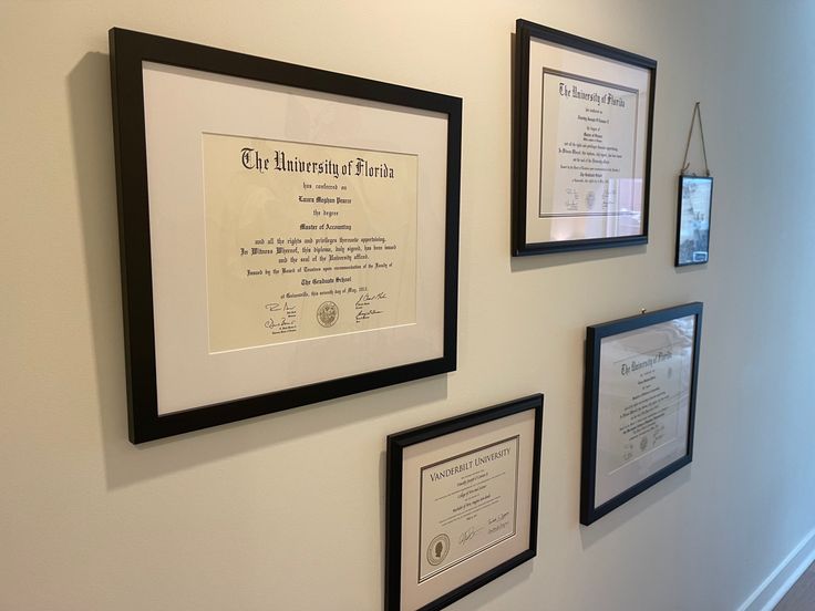 a group of framed pictures on the wall next to each other with plaques attached to them