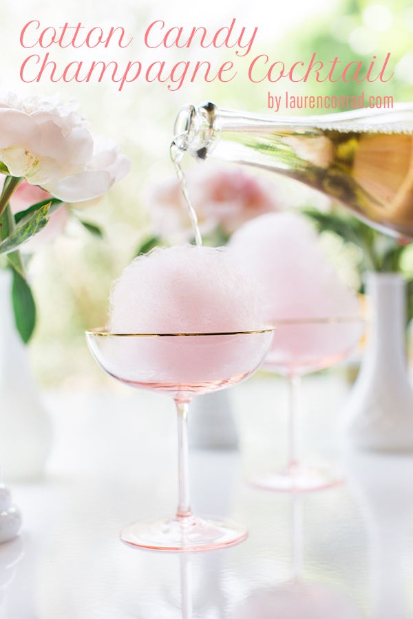 two wine glasses filled with ice cream sitting on top of a table next to flowers