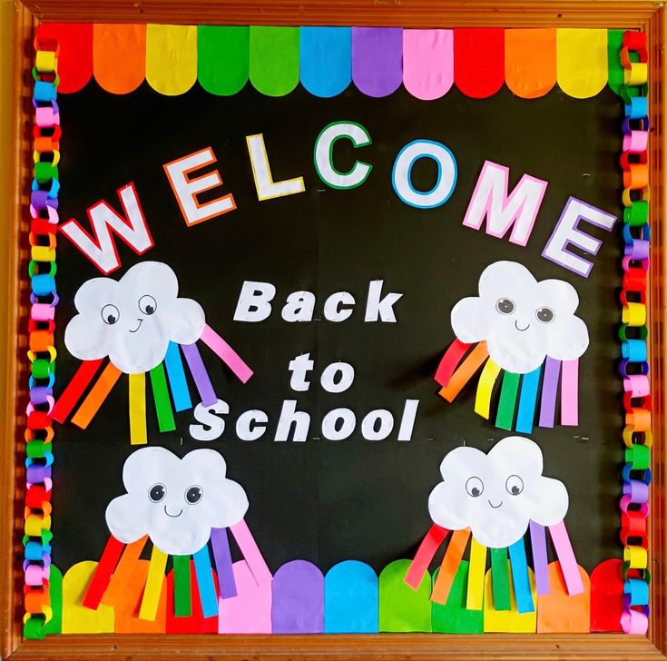 a welcome back to school sign made out of construction paper with rainbows and clouds