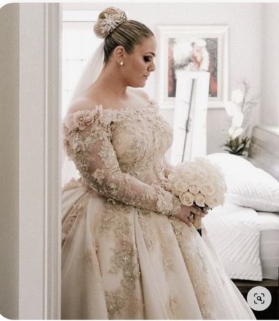 a woman in a wedding dress is holding flowers