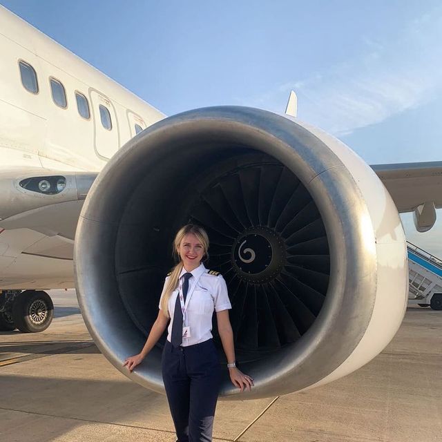 a woman standing in front of an airplane engine