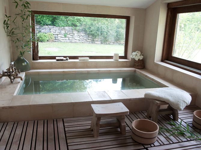 an indoor jacuzzi is shown in the middle of a room with large windows