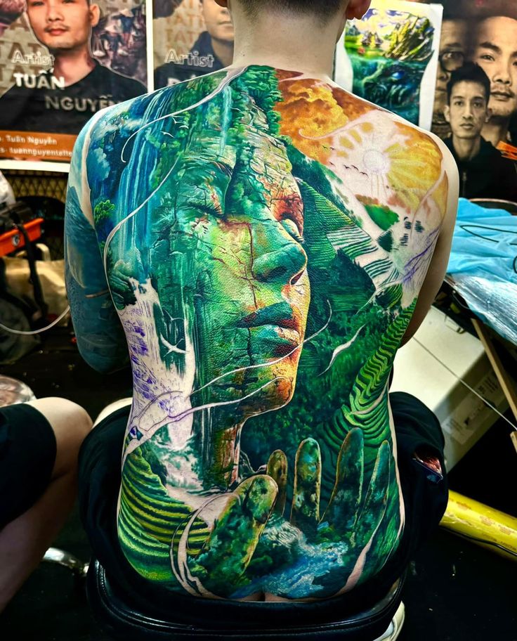 the back of a man's body covered in tattoos and artwork, with images of people