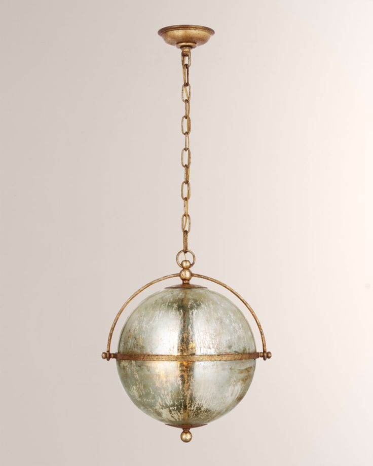 a glass ball hanging from a brass chain