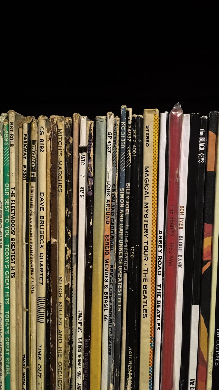 a book shelf filled with lots of books on top of each other in front of a black background