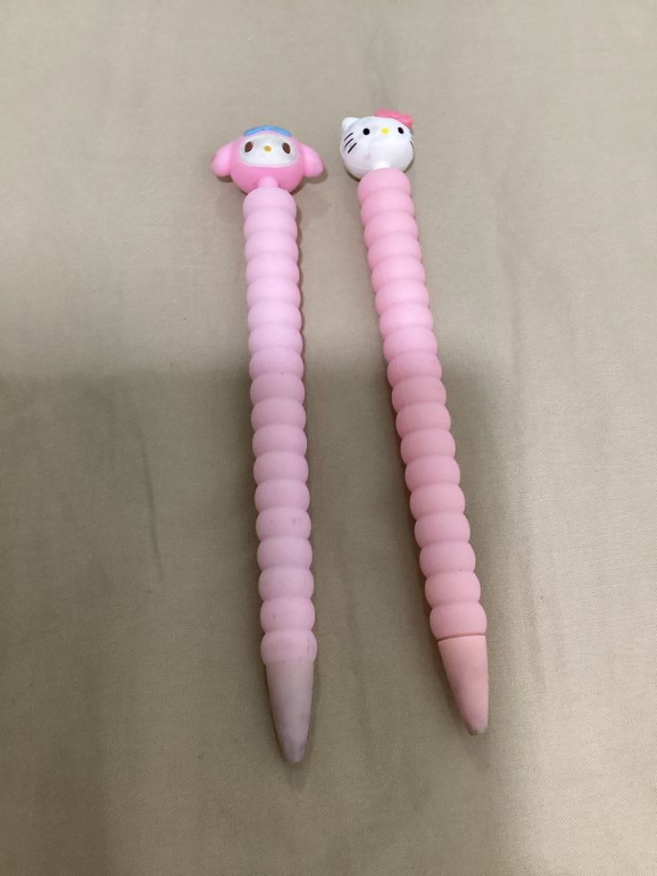 two pink hello kitty toothbrushes laying next to each other