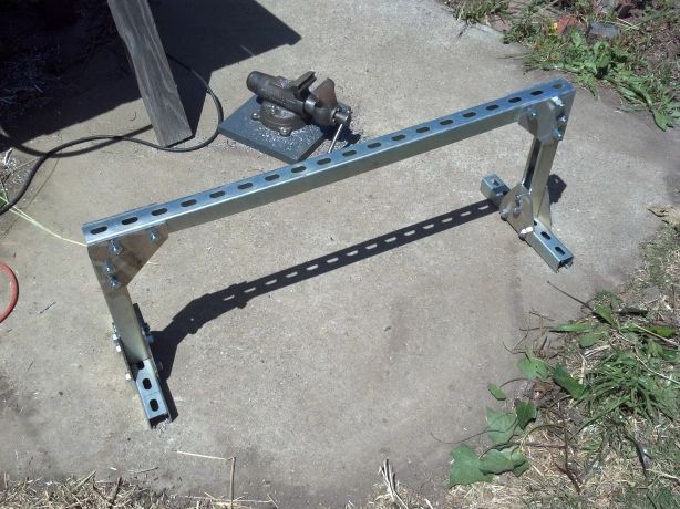 a metal bench sitting on top of a cement ground next to a power cord and plugged in