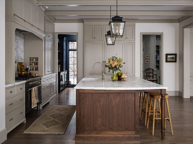 a large kitchen with an island in the middle and two stools next to it