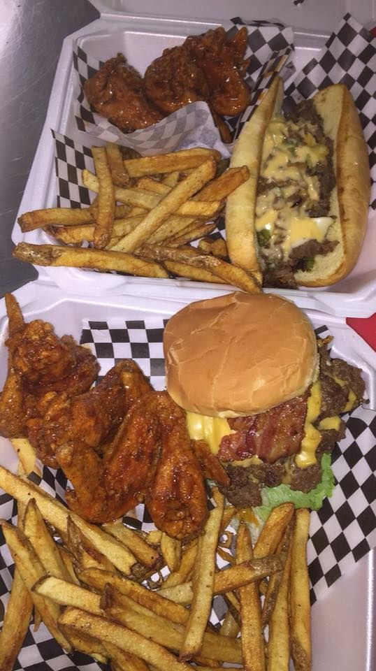 two trays filled with food sitting on top of a checkered tablecloth covered table