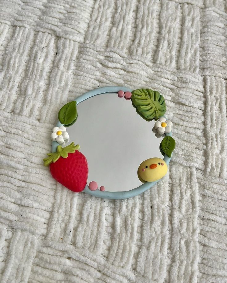 a mirror that has some fruit on it and is sitting on a bed with white sheets