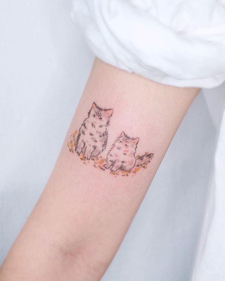 a woman with a cat tattoo on her arm and the other one is sitting down