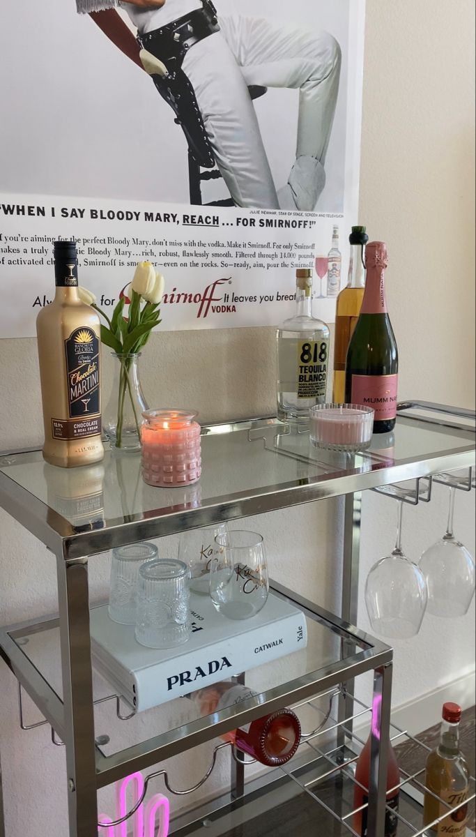 a bar cart with bottles and glasses on it