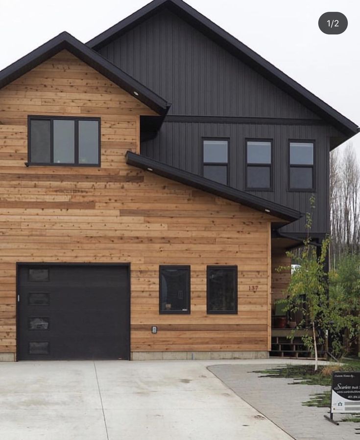 a large wooden house with two garages on the front and one above it's door