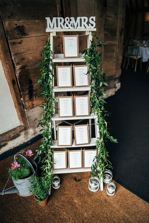 a table with seating cards and greenery on it