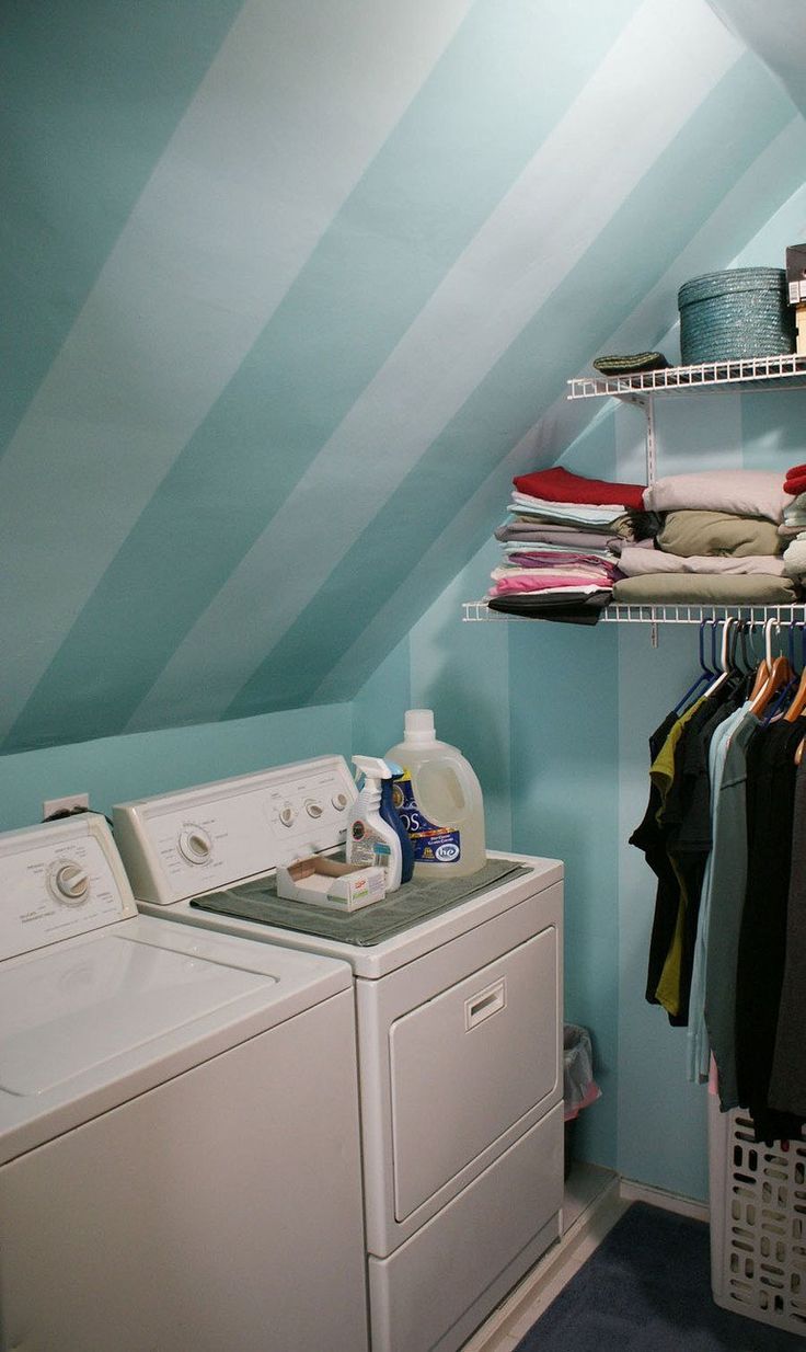 a washer and dryer in a small room with striped wallpaper on the walls