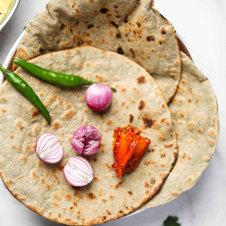 two tortillas on a plate with some vegetables