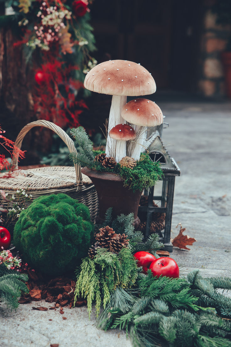 two mushrooms sitting on top of a table next to christmas wreaths and other decorations