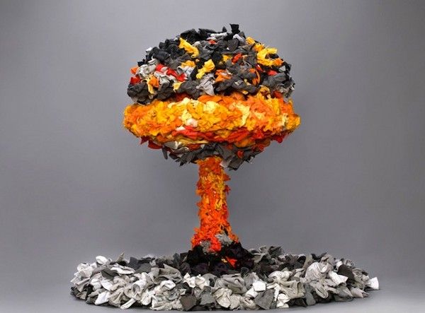 an orange and black object is on top of some silver foil chips in front of a gray background