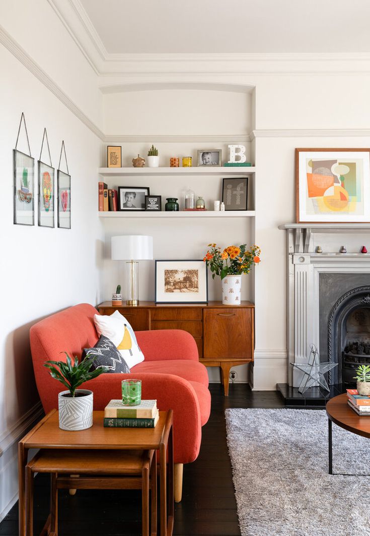 a living room filled with furniture and a fire place in front of a white wall