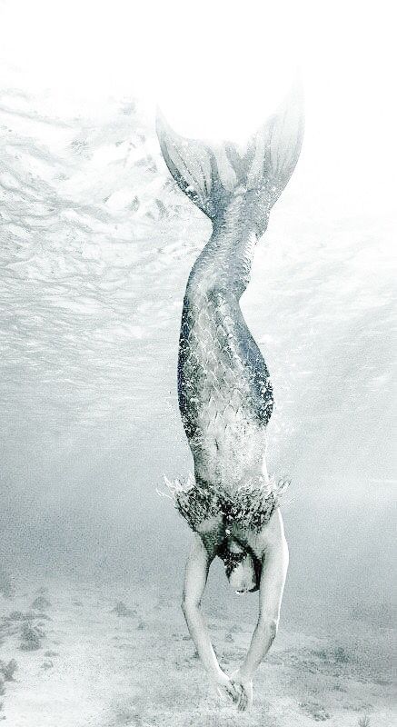 a woman diving in the water with her back turned to look like she's floating