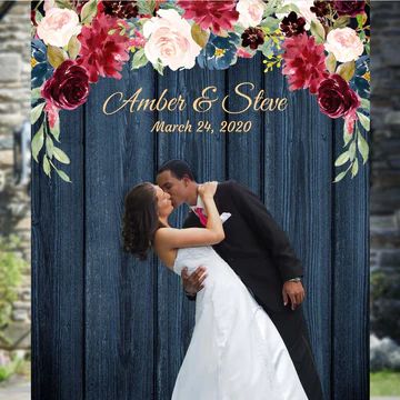 a bride and groom kissing in front of a wooden fence with flowers on it for their wedding day