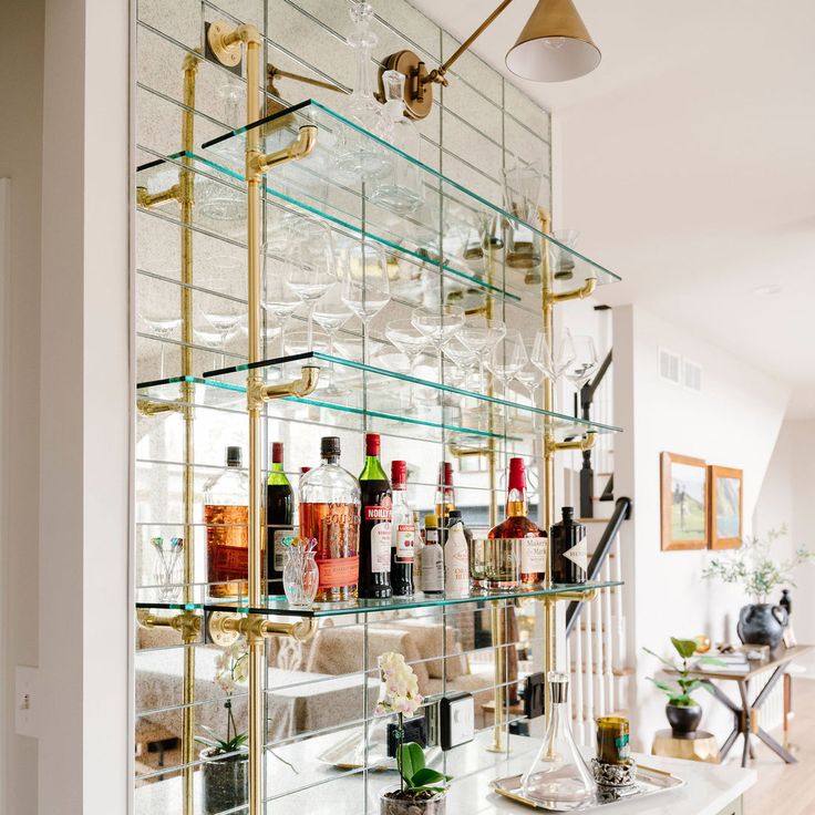 a bar with lots of bottles and glasses on it's glass shelving unit