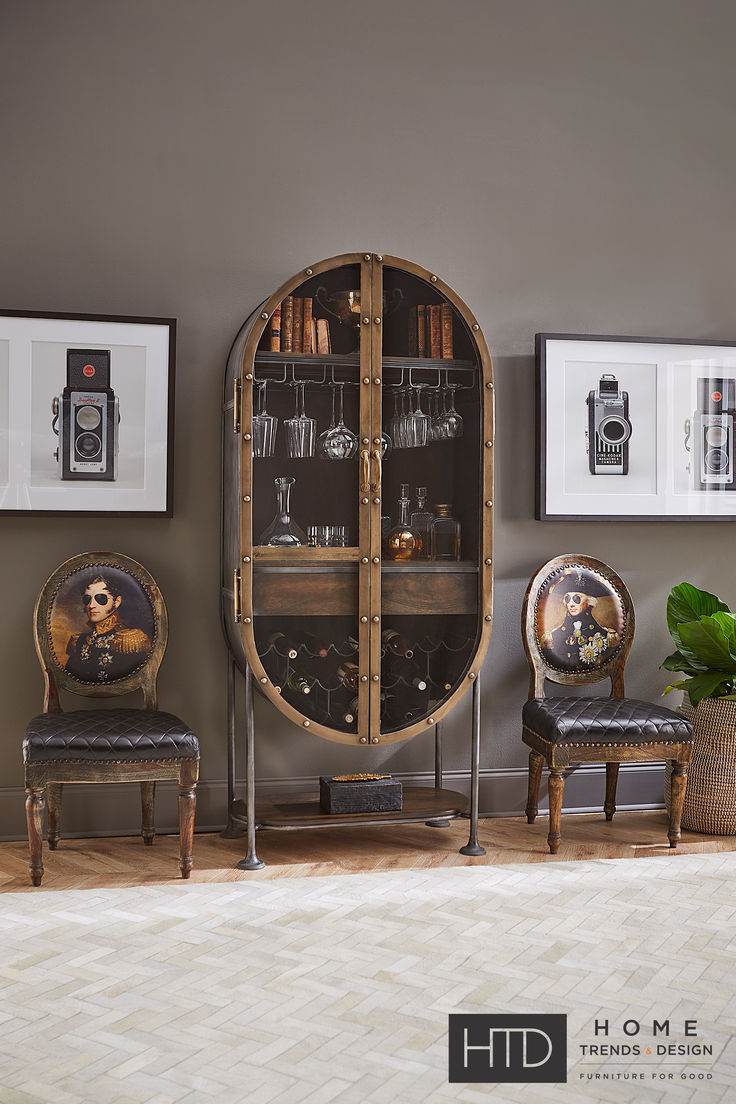 two chairs and a cabinet in a room with pictures on the wall