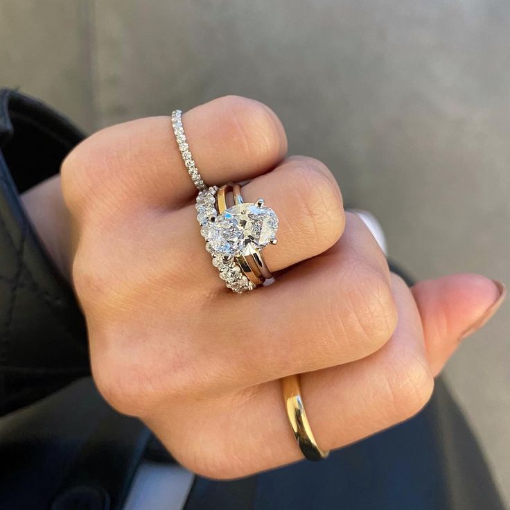 a woman's hand holding a diamond ring