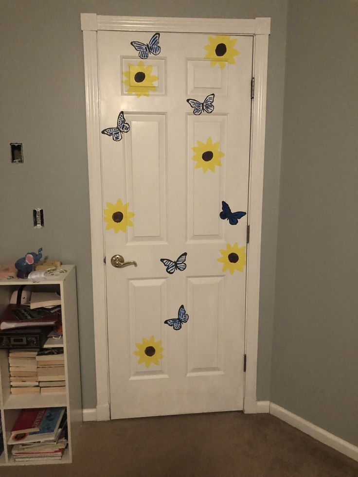 a white door with sunflowers and butterflies painted on it