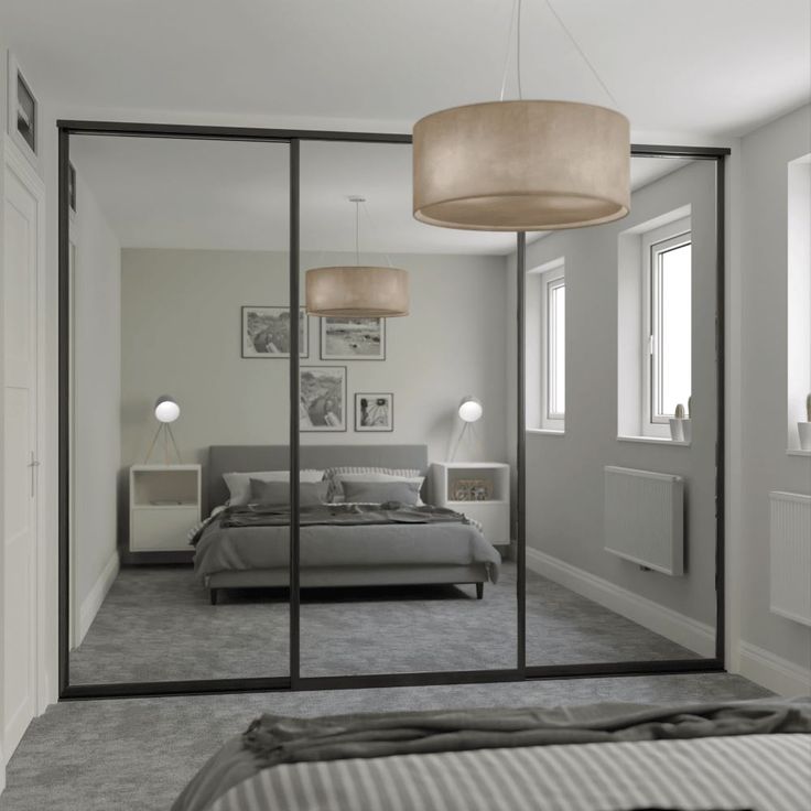 a bedroom with mirrored walls and a bed in the middle, two lamps hanging from the ceiling