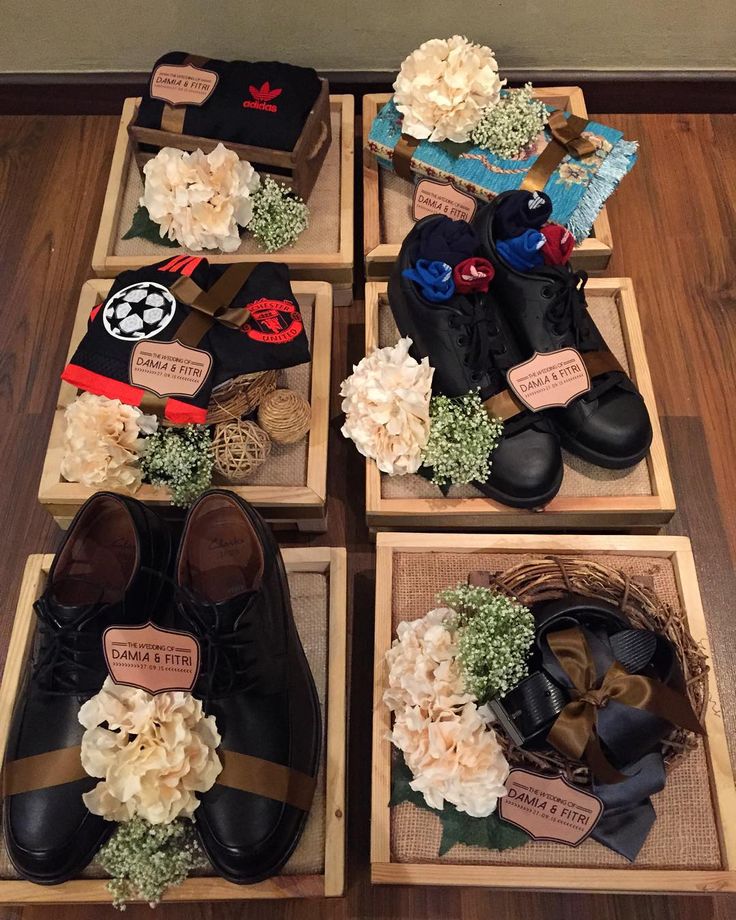 there are many pairs of shoes on display in wooden boxes with flowers and ribbons around them