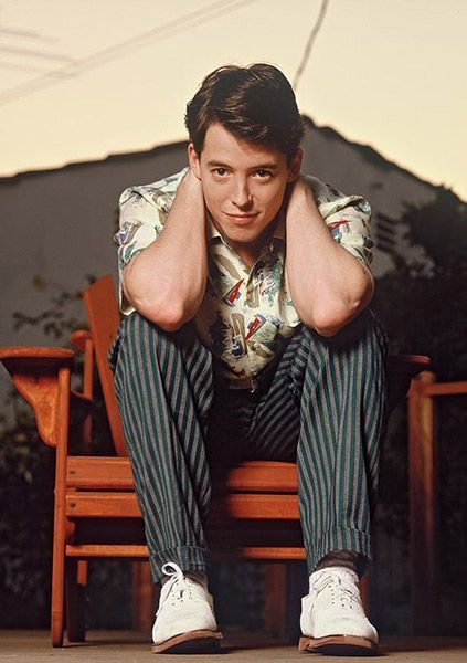 a young man sitting on top of a wooden bench