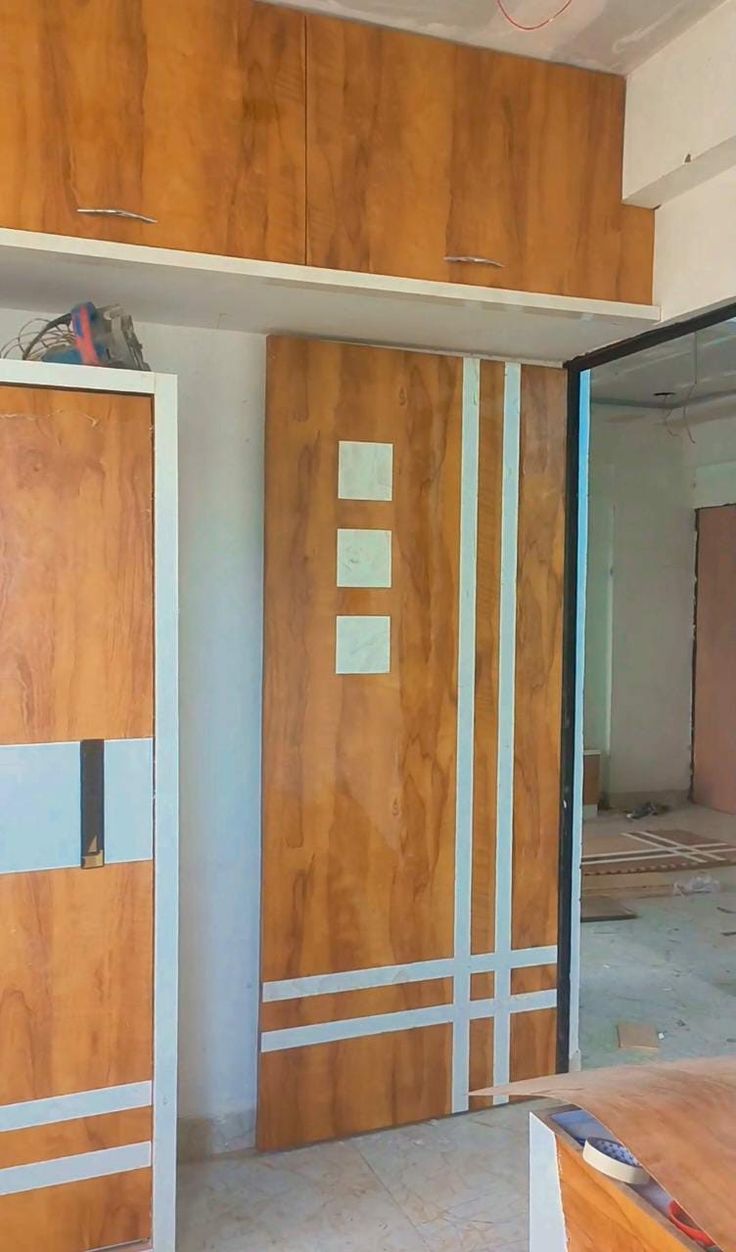 an unfinished room with wooden doors and no one in the house or someone is working on it