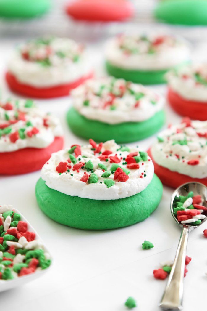 green and red cookies with white frosting and sprinkles are on a table