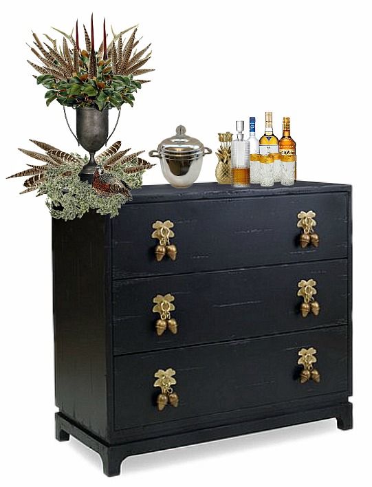 a black dresser topped with lots of bottles and plants