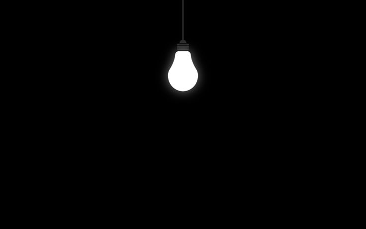 a light bulb hanging from a ceiling in the dark with only one light on it