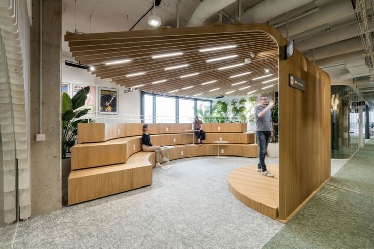 people are standing in the middle of a room with wooden benches and planters on the walls