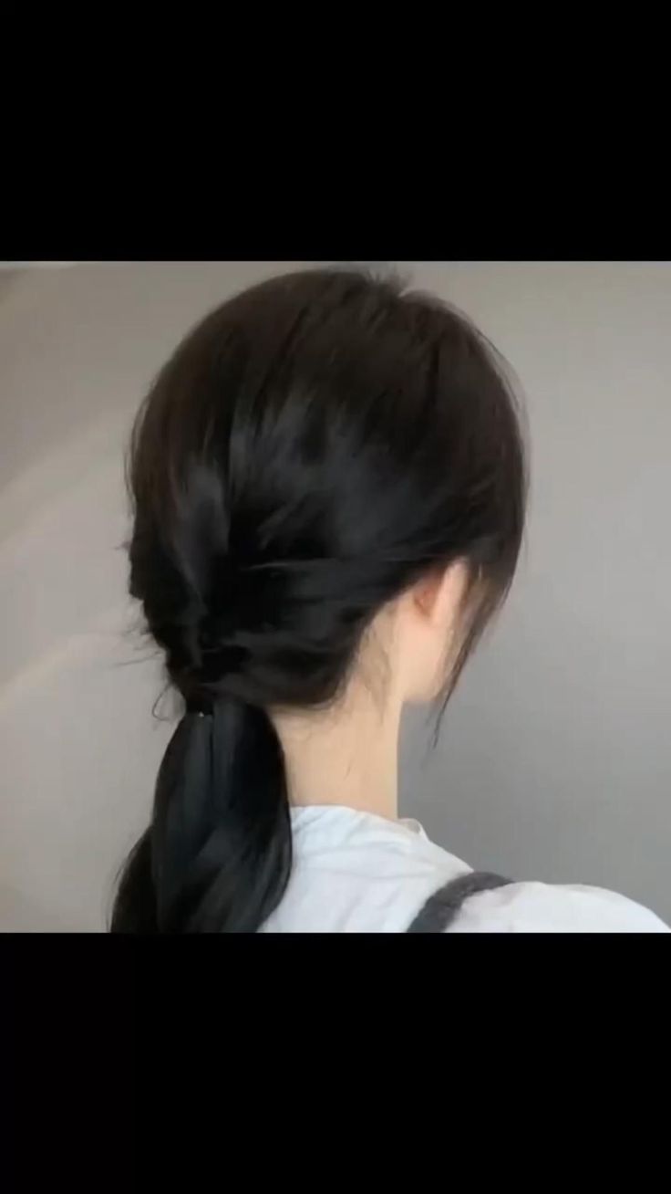 a woman with long black hair in a ponytail