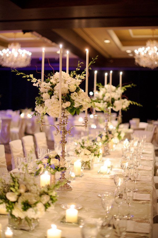 a long table with white flowers and candles