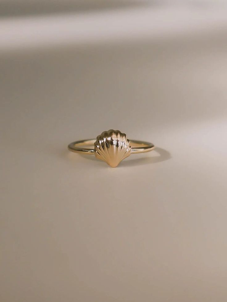 Inspired by Venus, the goddess of love, to celebrate love and relationships. First handcrafted from wax and then cast in gold, this ring's design echoes the delicate curves of a seashell, capturing the essence of Venus’s oceanic origins. Each piece honors the beauty and harmony of nature, making it a perfect symbol of romance and new beginnings. A must-have for your jewelry collection. Shell measures approximately 8 mm. Band thickness is 1.3 mm. Shiny finish or matte finish. Made with 10K solid yellow or white gold. Shell Engagement Ring, Handmade Delicate 14k Gold Rings, Delicate Handmade 14k Gold Rings, 14k Gold Pearl Promise Ring, Handmade 14k Yellow Gold Midi Rings, 14k Gold Hand Forged Promise Ring, Hand Forged 14k Gold Engraved Promise Ring, Hand Forged Recycled Gold Dainty Rings, Gold 14k Pearl Promise Ring