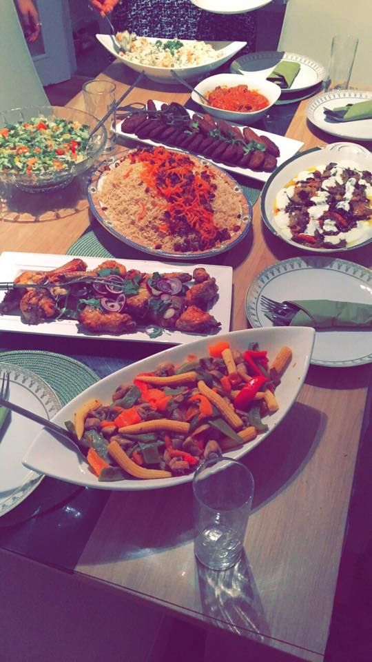 a table filled with plates and bowls full of different types of food, including vegetables