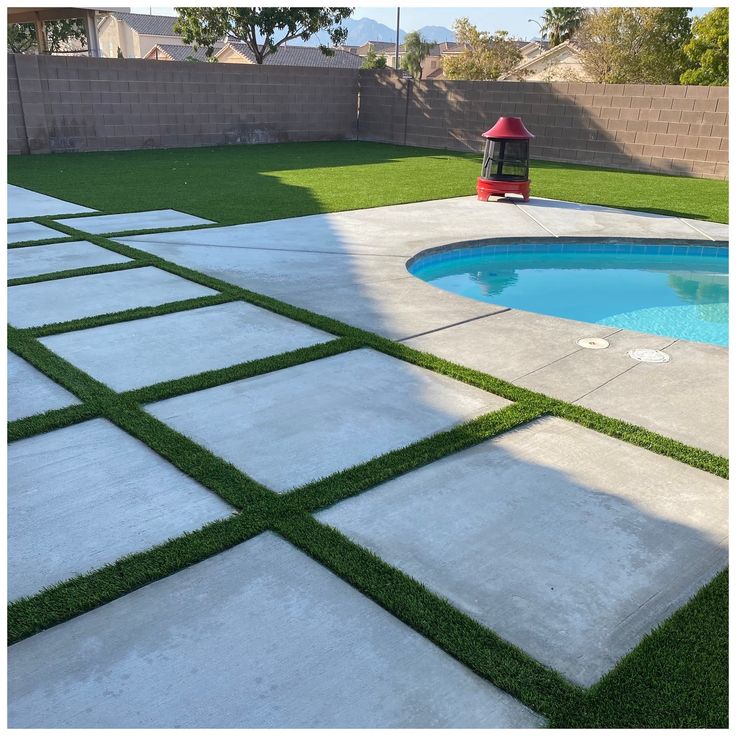 a backyard with artificial grass and a pool