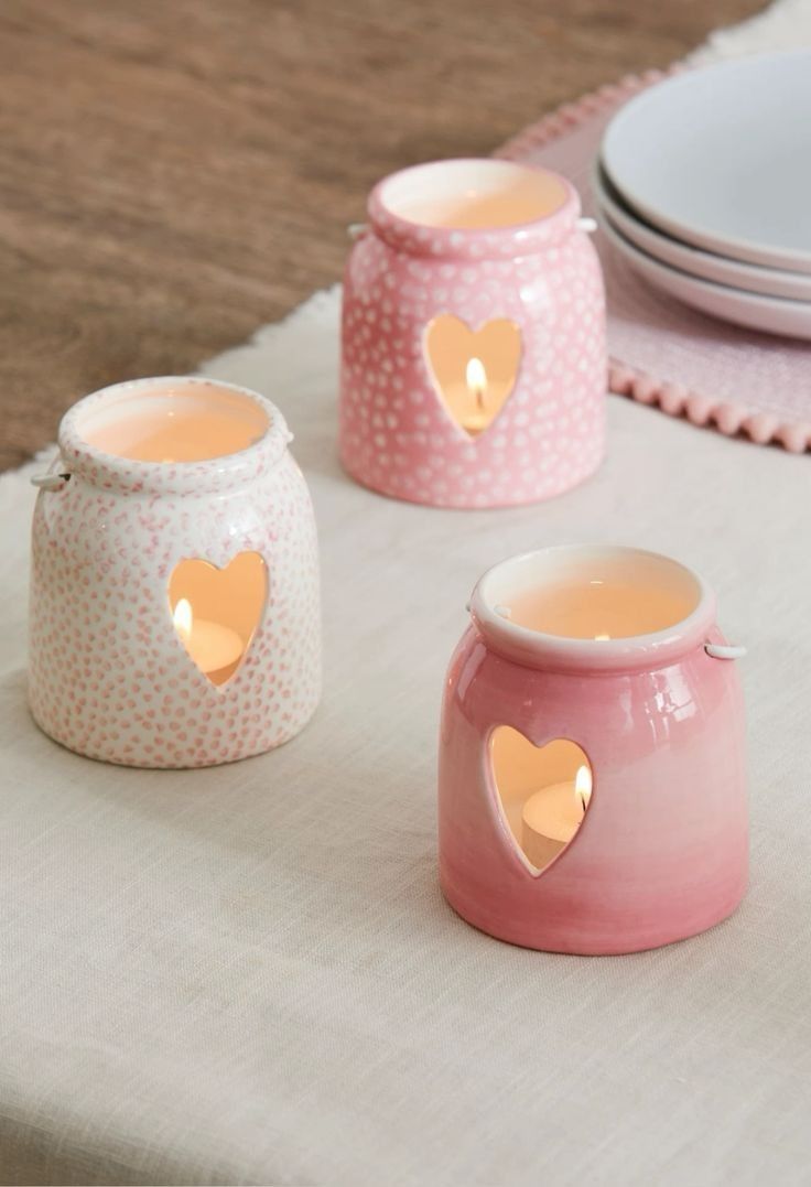 three pink and white vases sitting on top of a table