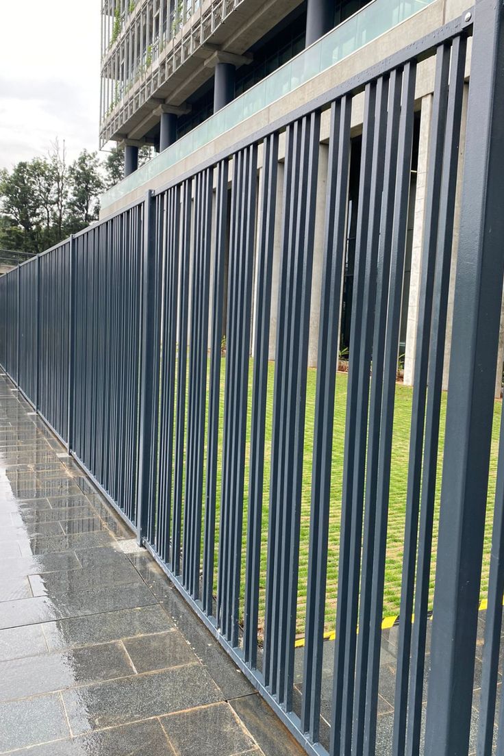 a long metal fence next to a building