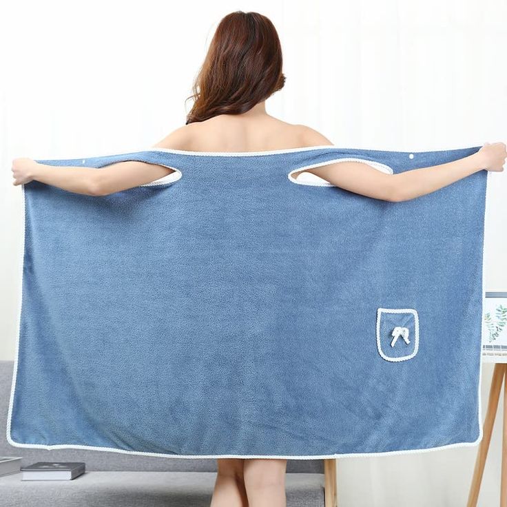 a woman is holding up a blue towel