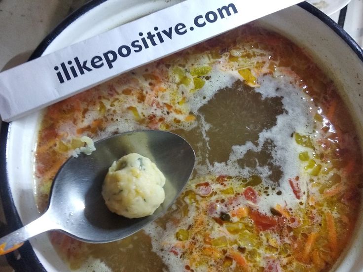 a spoon in a bowl filled with soup and some sort of substance on the side