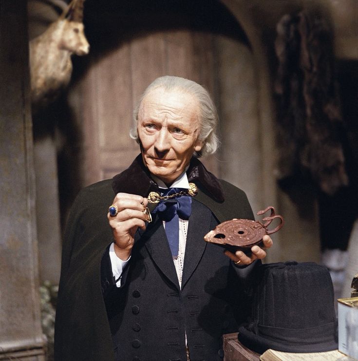 an old man in a tuxedo and bow tie holding a piece of metal