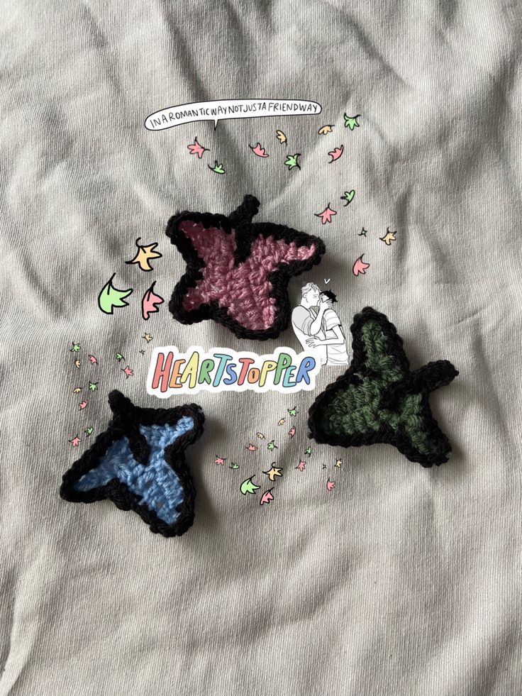 three small crocheted stars on top of a white sheet with confetti sprinkles