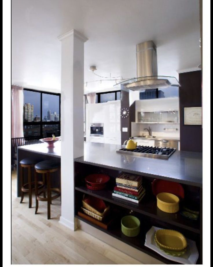 a kitchen with a stove top oven sitting next to a counter filled with plates and bowls