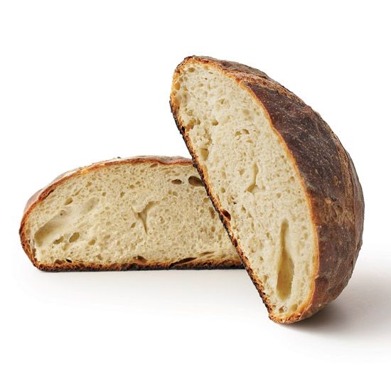 a loaf of bread cut in half on a white surface